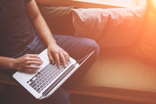 Photo of a person with a laptop on lap