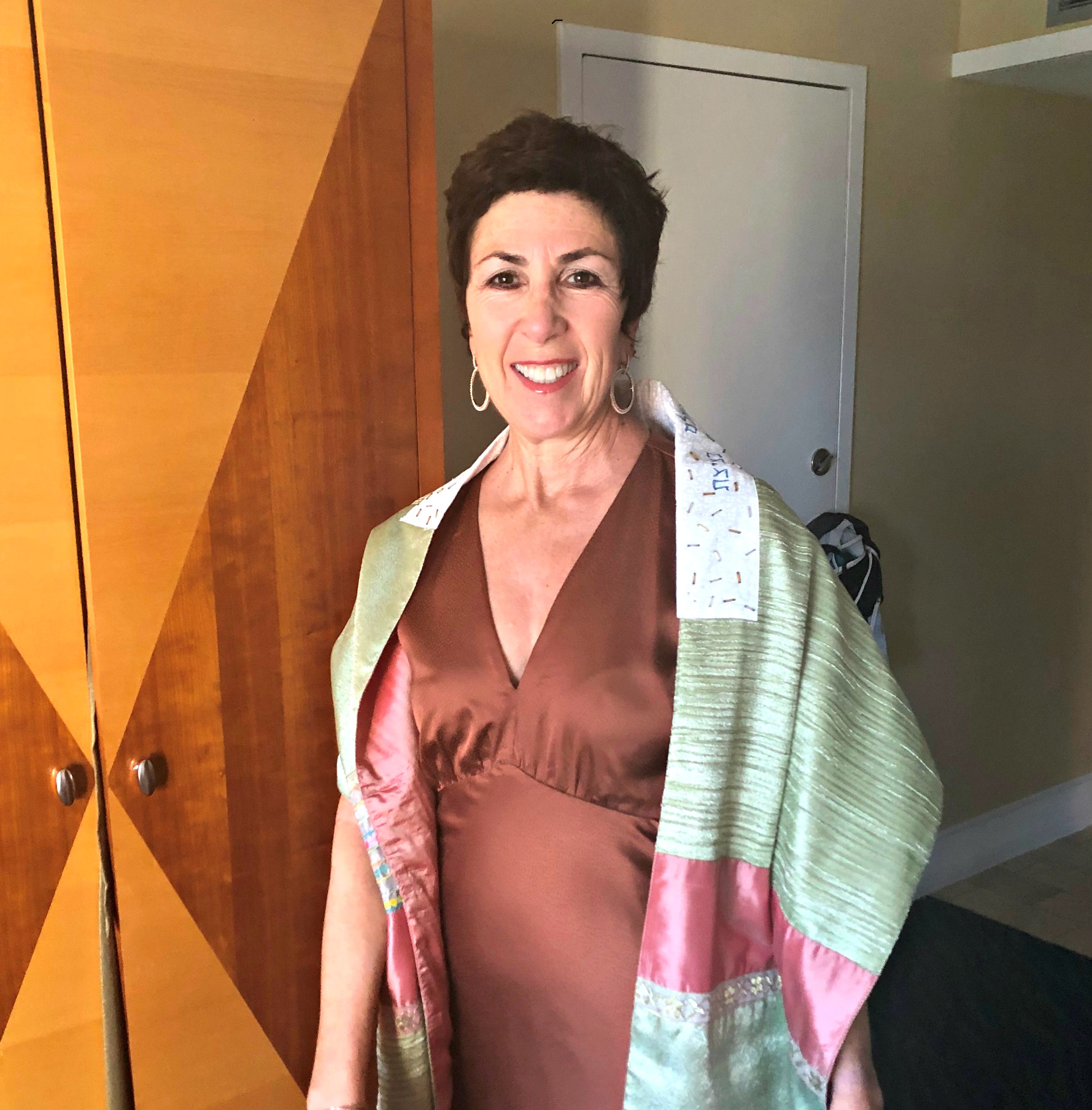 Smiling short haired woman wearing a pray shawl