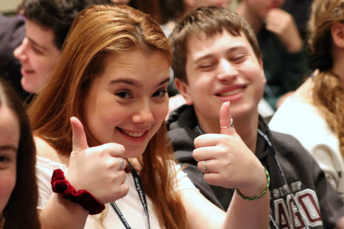 Smiling teen girl with two thumbs up