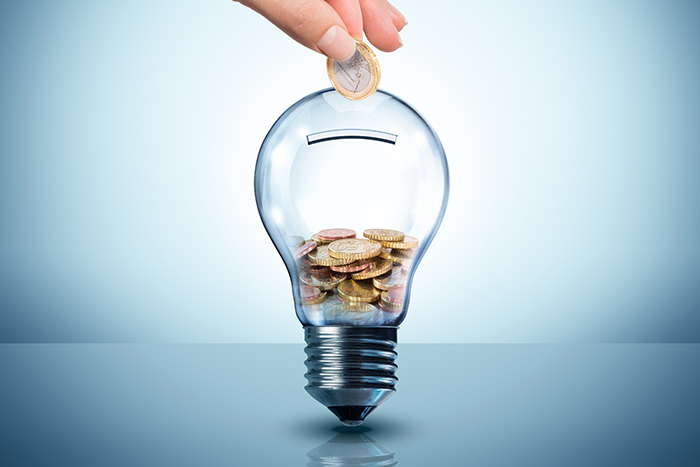 hand putting coins into a light bulb