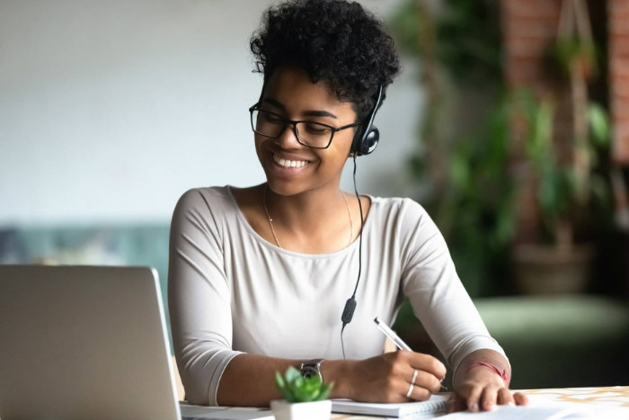 Woman smiling while facing a laptop