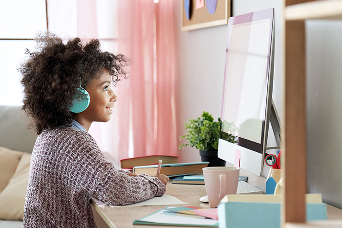 child working at a computer and smiling