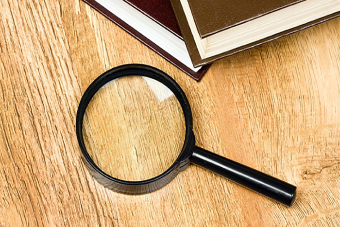 magnifying glass and books on a desk