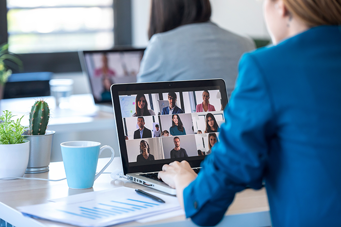 an image of a person on a Zoom call with eight other people on the computer screen