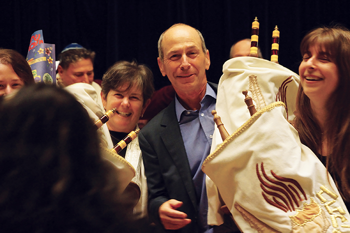 this image is of three people, each holding a Torah