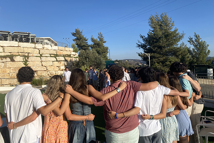 an image of teens in Israel in a line with their arms around each other