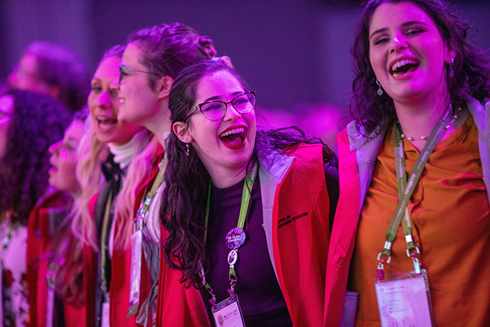 an image of a group of people singing with their arms around each other at Biennial