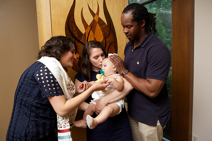 an image of an interfaith family holding a baby