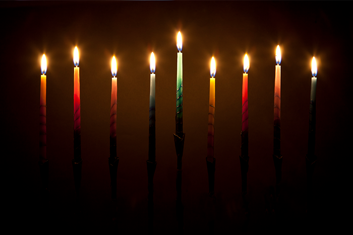 A lit menorah with a black background