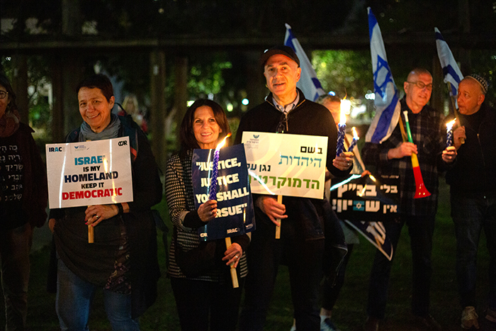 People holding signs at a protest in Israel supporting democracy