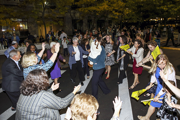 Photo of a group of people dancing with the Torah in the streets of Boston for Simchat Torah
