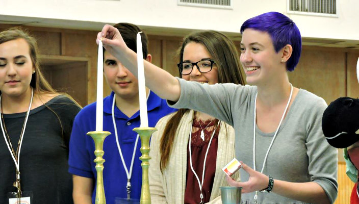 Group of teens lighting Shabbat candles