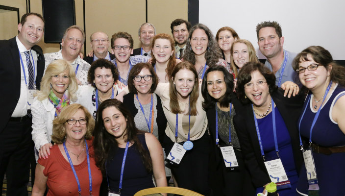 Group of people smiling together at the 2015 URJ Biennial wearing conference badges