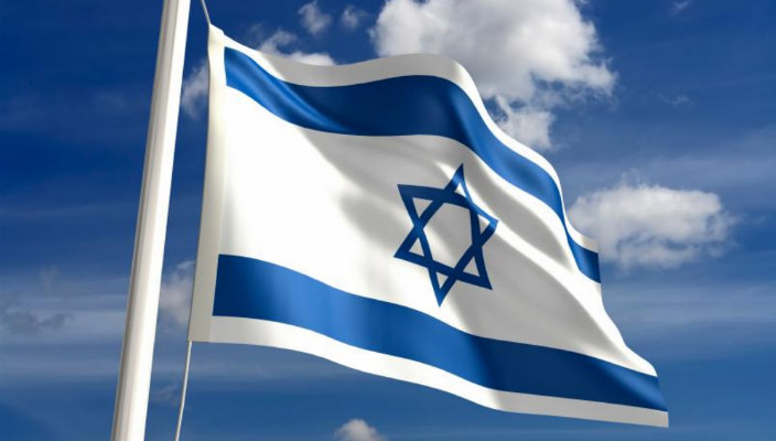 Israeli flag blowing in the wind against a blue sky