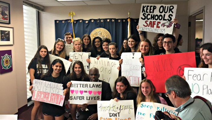 Group of two dozen Jewish teens holding gun violence prevention signs 