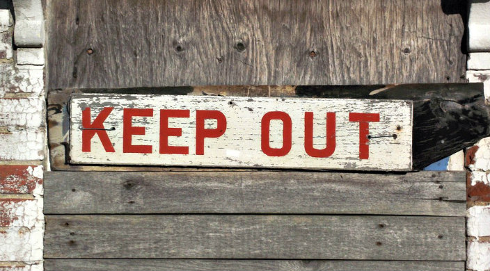 Painted sign on wood reading KEEP OUT