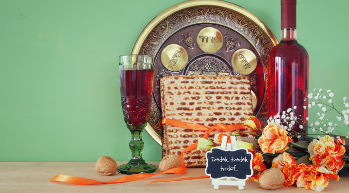 Passover seder setup with a small chalkboard that reads Tzedek Tzedek Tirdof