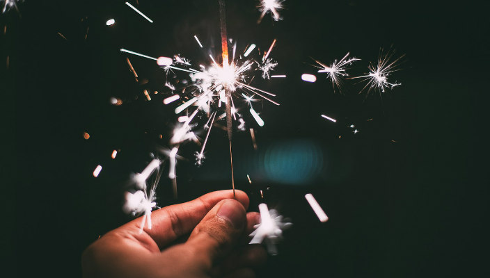 Closeup of hand holding a sparkler in the dark