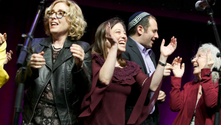 People smiling and clapping onstage at a URJ Biennial