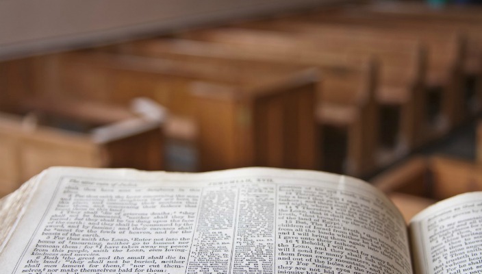 View of empty sanctuary pews from pulpit with Bible on it