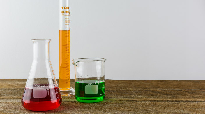 Beekers and other laboratory tools filled with colorful liquids as though ready for scientific experimentation