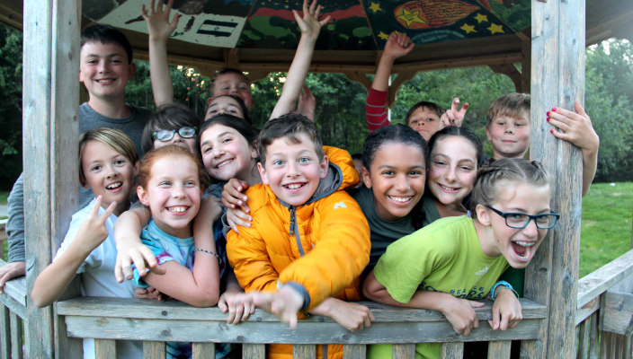 Smiling kids packed into a gazebo at camp 