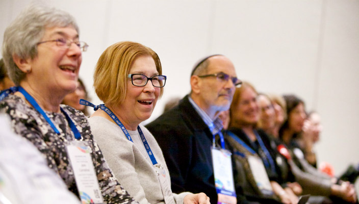 Biennial attendees sitting in a row and laughing