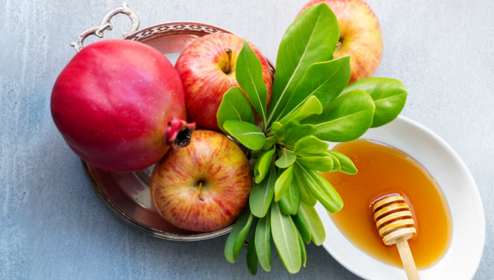 Rosh HaShanah flatlay with honey and pomegranates and apples