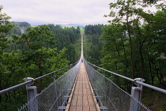 person crossing a suspension bridge
