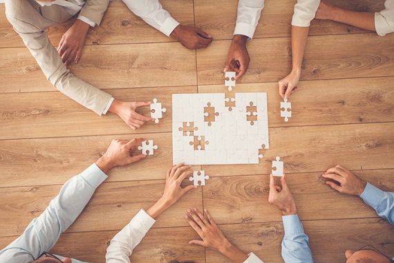 overhead view of people putting together a puzzle