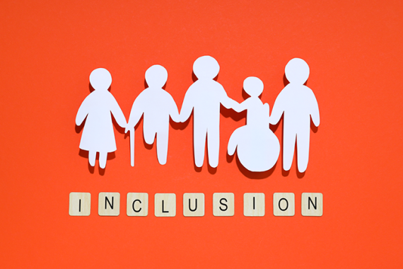 Photo of paper cutouts of five people, one with a cane and one in a wheelchair, with the word "inclusion" underneath