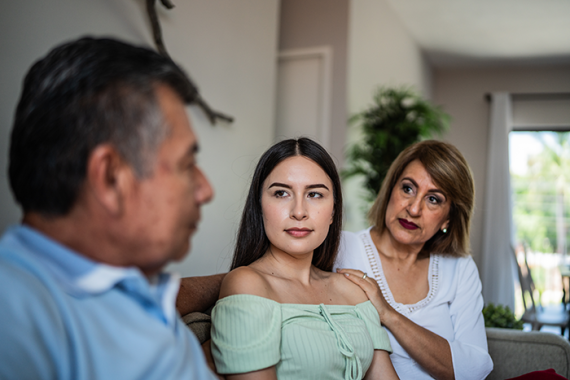 Photo of a family talking in the living room at home