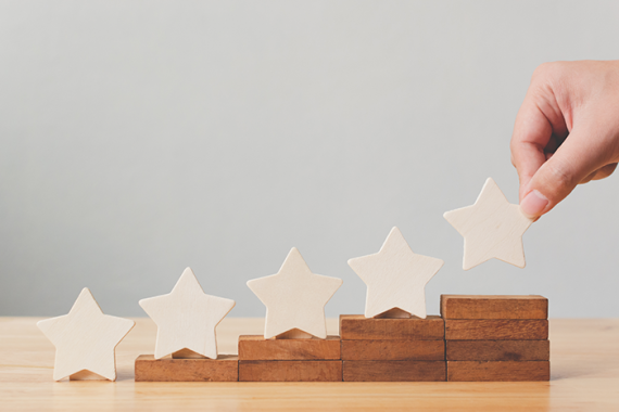 Photo of a hand putting a wooden five star shape on table.