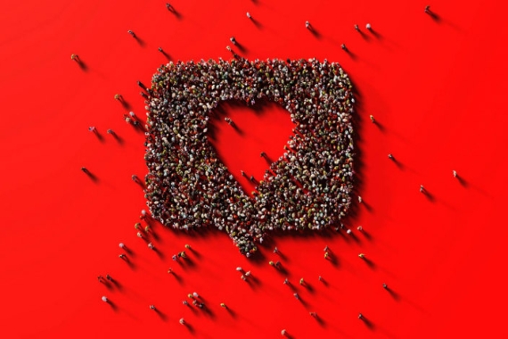 Human crowd forming a speech bubble with a heart shape inside representing an Instagram reaction icon