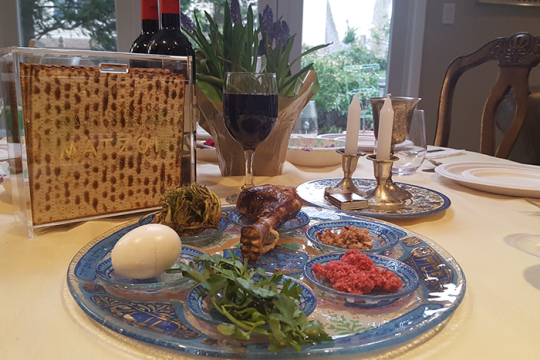 an image of a table set up for passover, with a seder plate and a box of matzah