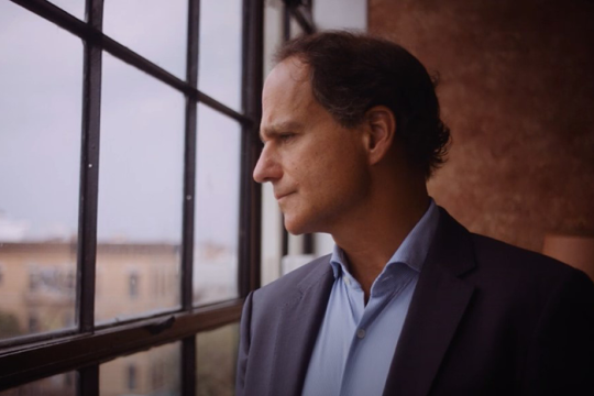 an image of rabbi jonah pesner staring out a window