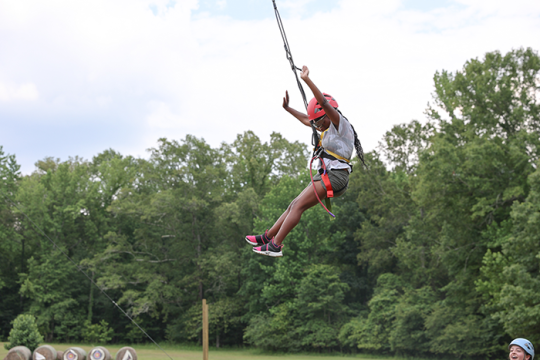 an image of a camper swinging from a bungee cord at Camp Dream Street at Henry S. Jacobs Camp