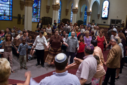 Photo of a group of people standing in a circle holding hands