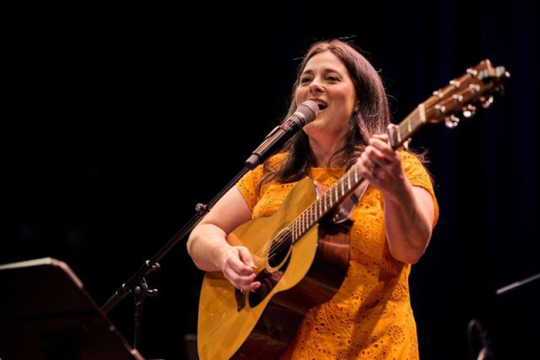 Photo of musician Elana Arian playing the guitar