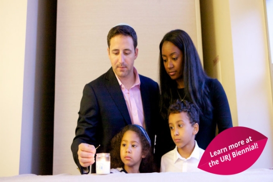 Young couple and their children lighting the Shabbat candles together