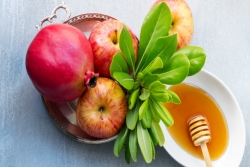Rosh HaShanah flatlay with honey and pomegranates and apples