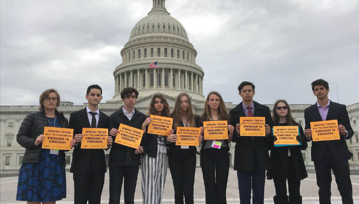 Teens holding gun prevention violence signs in front of the Capitol Building